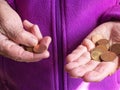 Woman`s hands are holding a few euro coins. Pension, poverty, social problems and the theme of old age. Saving. Royalty Free Stock Photo