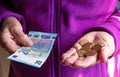 Woman`s hands are holding a few euro coins. Pension, poverty, social problems and the theme of old age. Saving. Royalty Free Stock Photo