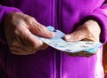 Woman`s hands are holding a few euro coins. Pension, poverty, social problems and the theme of old age. Saving. Royalty Free Stock Photo