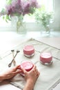 Woman`s hands holding glass of homemade berry smoothie over white napkins in the kitchen table.Healthy breakfast.