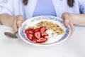 Woman`s hands holding homemade granola with fresh organic strawberries and yogurt in the vintage plate. Royalty Free Stock Photo