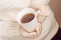 Woman`s hands holding hot cup of coffee