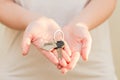 Woman's hands holding key with keychain in shape of the house Royalty Free Stock Photo