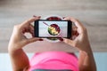 Woman`s hands holding mobile phone while taking photograph to bowl with fresh fruit Royalty Free Stock Photo