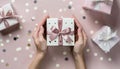 Woman\'s hands holding one gift or one present box decorated confetti on pink Royalty Free Stock Photo