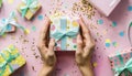 Woman\'s hands holding one gift or one present box decorated confetti on pink Royalty Free Stock Photo