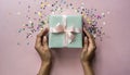 Woman\'s hands holding one gift or one present box decorated confetti on pink Royalty Free Stock Photo