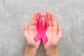 WomanÃ¢â¬â¢s hands holding pink breast cancer awareness ribbon. Healthcare and medicine concept. Breast cancer awareness month card