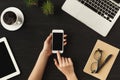 Woman`s hands holding a smartphone, top view Royalty Free Stock Photo