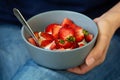 Woman`s hands holding smoothie or granola bowl topped with fresh strawberry. Healthy breakfast concept Royalty Free Stock Photo