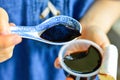 Woman`s Hands Holding Spoon with Black Chinese Herb Jelly Named Guiling Gao