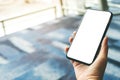 A woman`s hands holding and using black mobile phone with blank screen while sitting in the airport Royalty Free Stock Photo