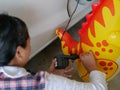 Woman`s hands holding and using mini air pump, connected to the car plug, to inflate a rocking doll Royalty Free Stock Photo