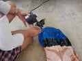 Woman`s hands holding and using mini air pump, connected to the car plug, to inflate a rocking doll Royalty Free Stock Photo