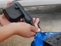 A woman`s hands holding and using mini air pump, connected to the car plug, to inflate a rocking doll Royalty Free Stock Photo