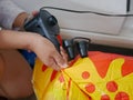 Woman`s hands holding and using mini air pump, connected to the car plug, to inflate a rocking doll Royalty Free Stock Photo