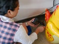 Woman`s hands holding and using mini air pump, connected to the car plug, to inflate a rocking doll Royalty Free Stock Photo