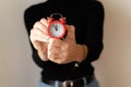 Woman& x27;s hands holds red alarm clock and sets the time. Businesswoman adjusting or changing the time on vintage clock Royalty Free Stock Photo