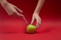 Woman`s hands inject poison into the green apple.