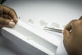 Woman`s hands inspecting rough diamonds with forceps.