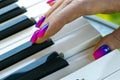 Woman`s hands on the keyboard of the piano closeup. Hands musician playing the piano. Top view. Hands pianist playing music on th