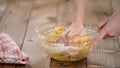 Woman`s hands knead dough on a table.