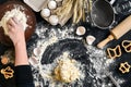 Woman`s hands knead dough on table with flour, eggs and ingredients. Top view. Royalty Free Stock Photo