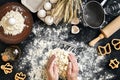 Woman`s hands knead dough on table with flour, eggs and ingredients. Top view. Royalty Free Stock Photo