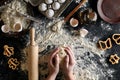 Woman`s hands knead dough on table with flour, eggs and ingredients. Top view. Royalty Free Stock Photo