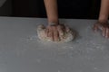 Woman`s hands kneading flour with a black background