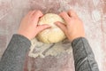 Womanâs hands kneading raw bread dough on a clear plastic mat, preparation for baking fresh bread