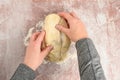 Womanâs hands kneading raw bread dough on a clear plastic mat, preparation for baking fresh bread