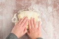 Womanâs hands kneading raw bread dough on a clear plastic mat, preparation for baking fresh bread