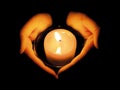 WOMAN'S HANDS LIT BY A CANDLE