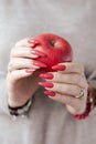 Woman`s hands and a bottle of red orange nail polish Royalty Free Stock Photo
