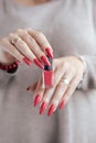 Woman`s hands and a bottle of red orange nail polish Royalty Free Stock Photo