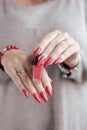 Woman`s hands and a bottle of red orange nail polish Royalty Free Stock Photo