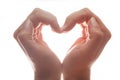 Woman's hands make a heart shape on white background, backlight. Love Royalty Free Stock Photo