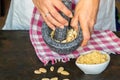 Woman`s hands making marzipan, grinding almond, pouring sugar and egg, stirring everything, making individual portions, and