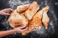 Woman`s hands making a pita bread with flour on dark wooden table