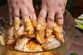 woman& x27;s hands marinate chicken wings in soy sauce, cream and garlic