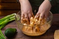 woman& x27;s hands marinate chicken wings in soy sauce, cream and garlic