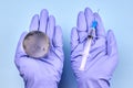 Woman's hands in medical gloves is holding a planet earth globe and a syringe Royalty Free Stock Photo