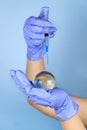 Woman's hands in medical gloves is holding a planet earth globe and a syringe Royalty Free Stock Photo