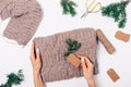 Woman's hands packing knitted wool sweater