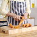 Woman& x27;s hands peeling carrot with a peeler. Conceptual image