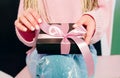 Woman`s hands with pink manicure holding black present box Royalty Free Stock Photo