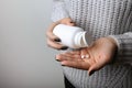 Woman`s hands pour pills from a bottle