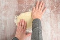 Womanâs hands pressing and spreading raw pizza dough on a clear plastic mat, preparation for baking