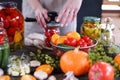 Woman`s hands rolls glass preserves with jars sealer. Making homemade vegetables for coronavirus crisis. Tomatoes, pumpkins,
